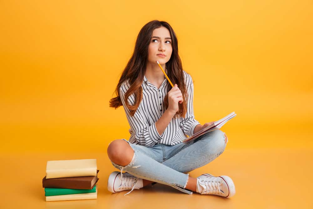 Niña pensativa tomando notas